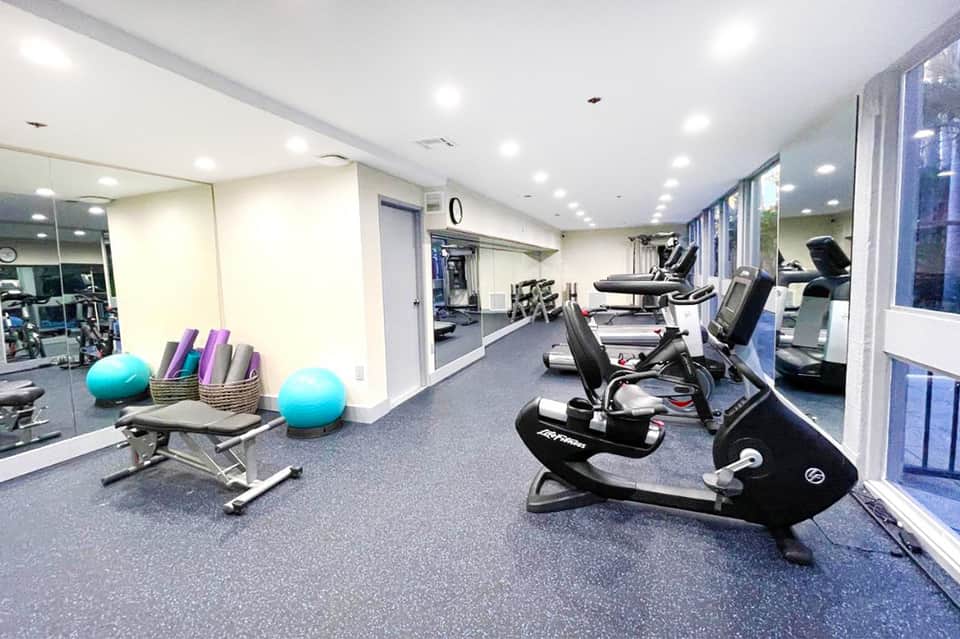 Modern fitness center with exercise bikes, equipment, and large windows