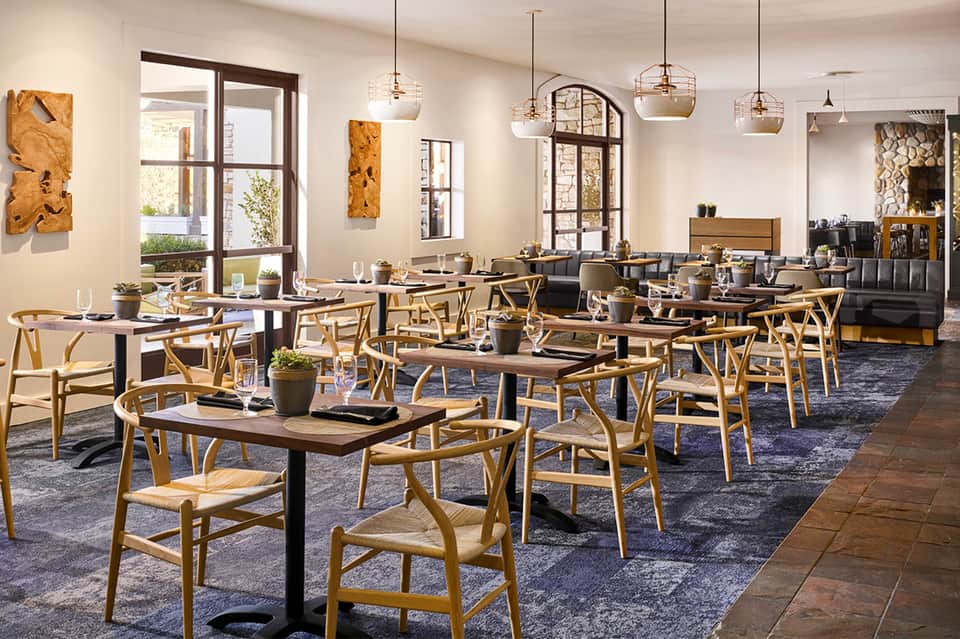 Contemporary restaurant dining room with wooden chairs and pendant lighting