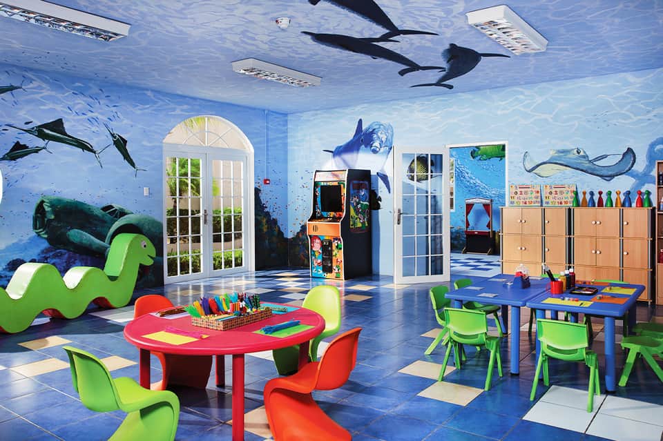 Colorful kids playroom with underwater mural, bright furniture, games, and activities