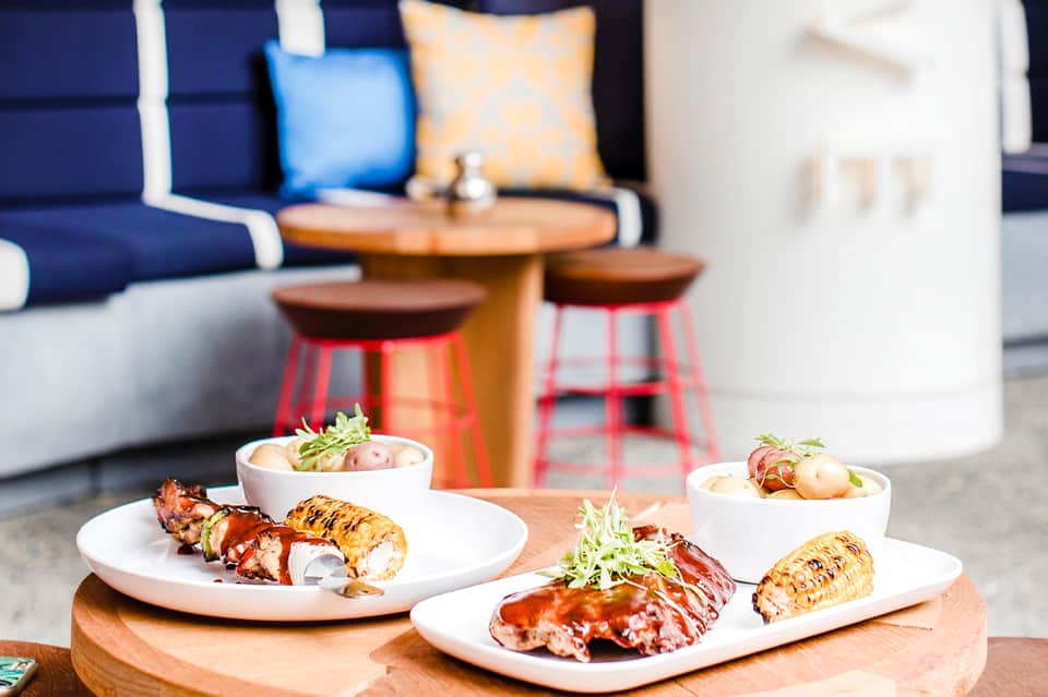 Grilled lobster tails plated elegantly with sides in upscale outdoor dining area