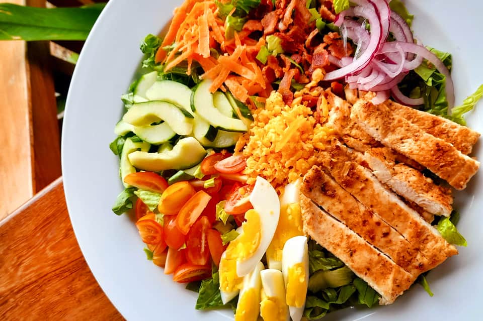 Grilled chicken salad with vegetables and rice on white plate