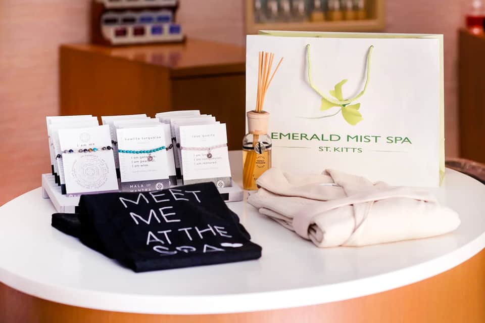 Spa reception desk displaying welcome items, bracelets, and Emerald Mist Spa St. Kitts branding