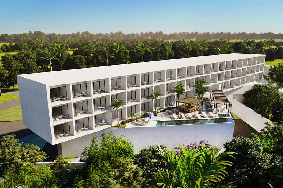 Aerial view of modern white residential complex with multiple units, pool area, and surrounding palm trees and forest