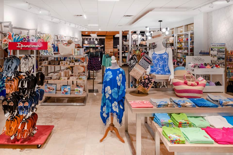 Bright retail shop interior displaying colorful beach apparel, accessories, and travel merchandise