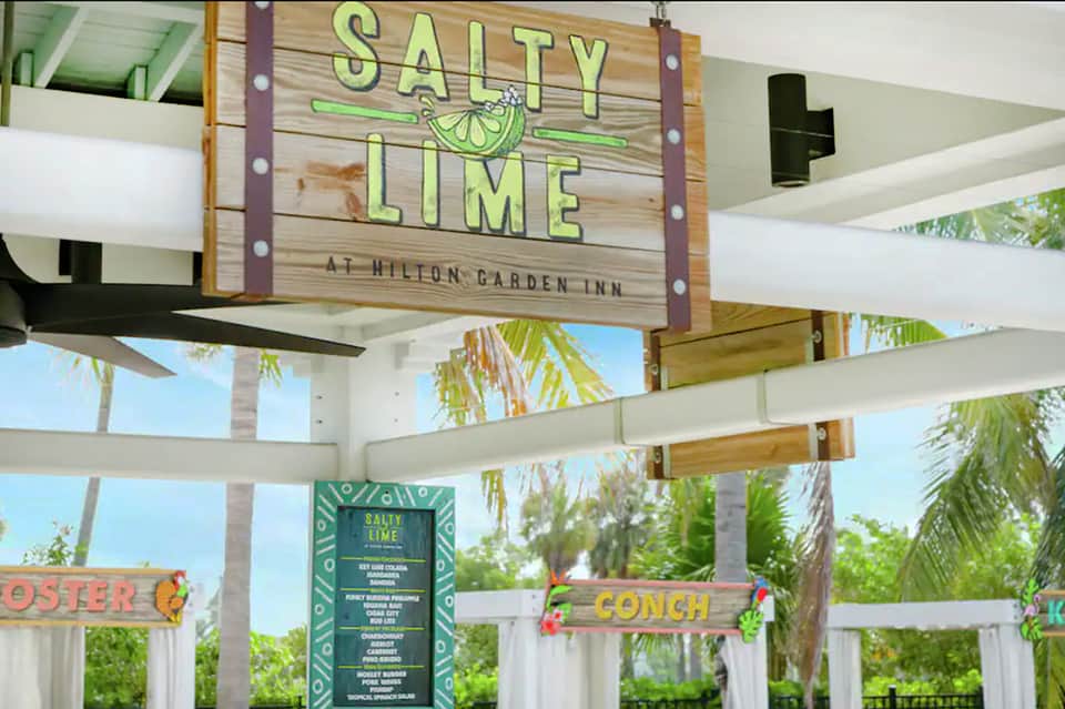 Salty Lime restaurant sign at Hilton Garden Inn with white pergola and palm trees