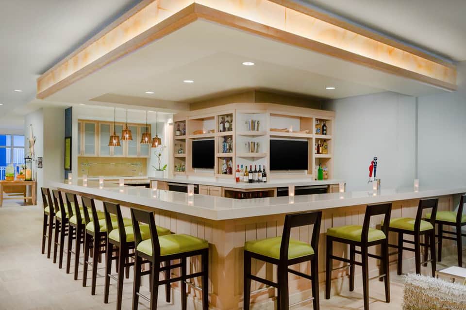 Modern bar with wooden accents, pendant lights, and bar seating