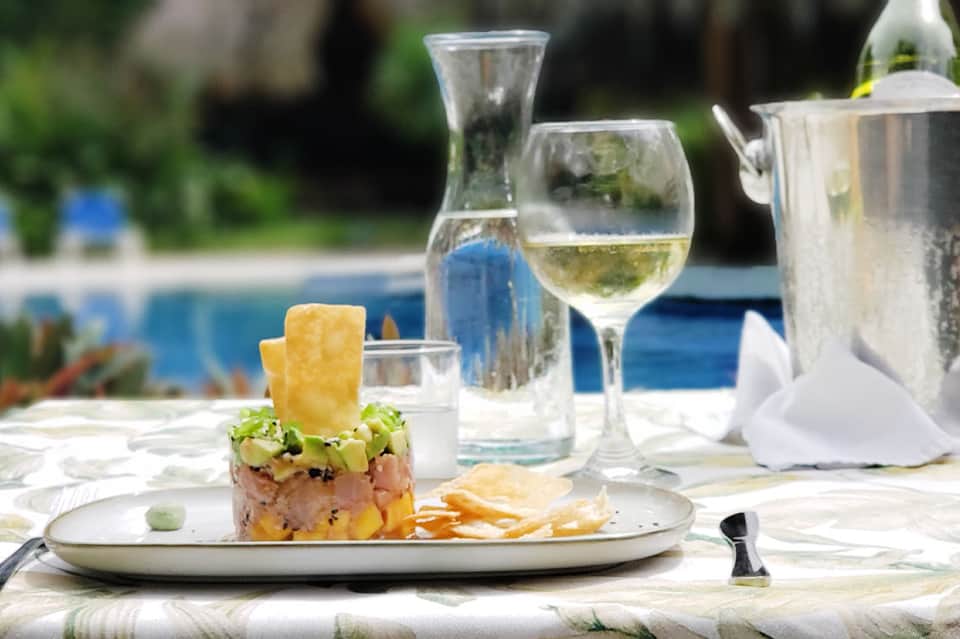 Fine dining plate with wine and beverages by the pool