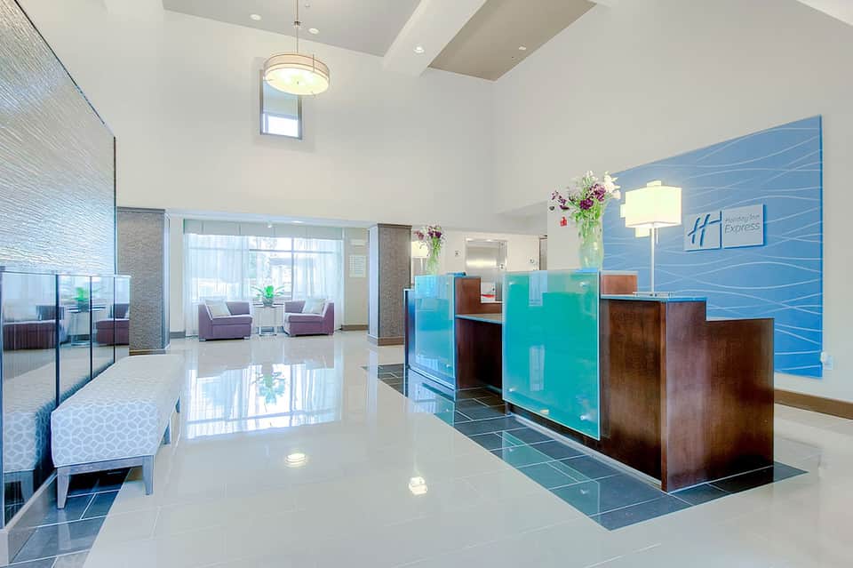 Bright modern hotel lobby with blue accent wall, reception desk, and contemporary furniture