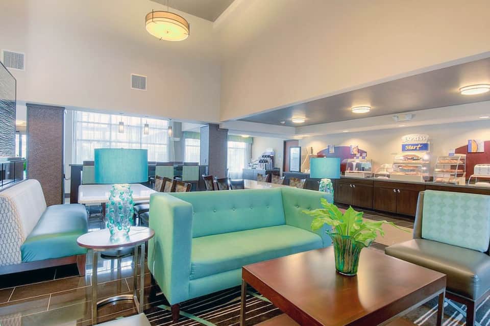 Hotel lobby lounge featuring turquoise sofa, bar area, and contemporary décor with ambient lighting