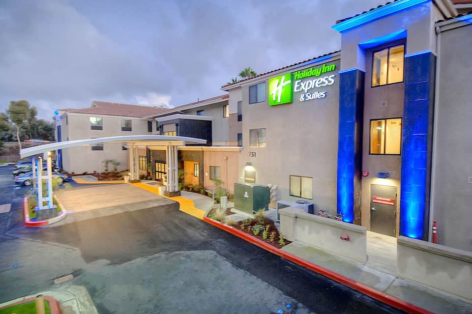 Holiday Inn Express & Suites exterior entrance illuminated at dusk with blue accent lighting