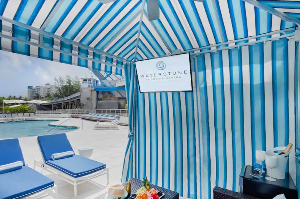 Waterstone Resort & Marina pool area with blue and white striped cabana tent and lounge chairs