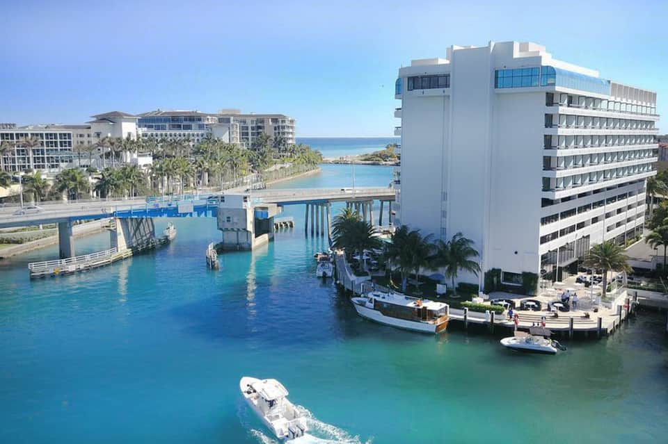 Coastal resort with white high-rise hotel overlooking turquoise waterway and boats