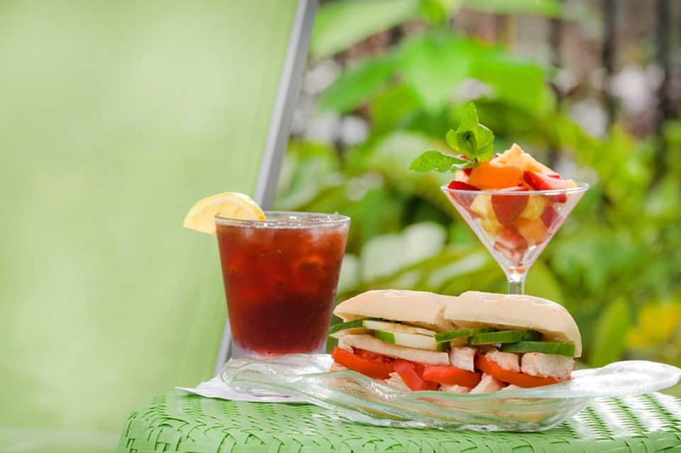 Gourmet sandwich and tropical cocktails served in garden setting