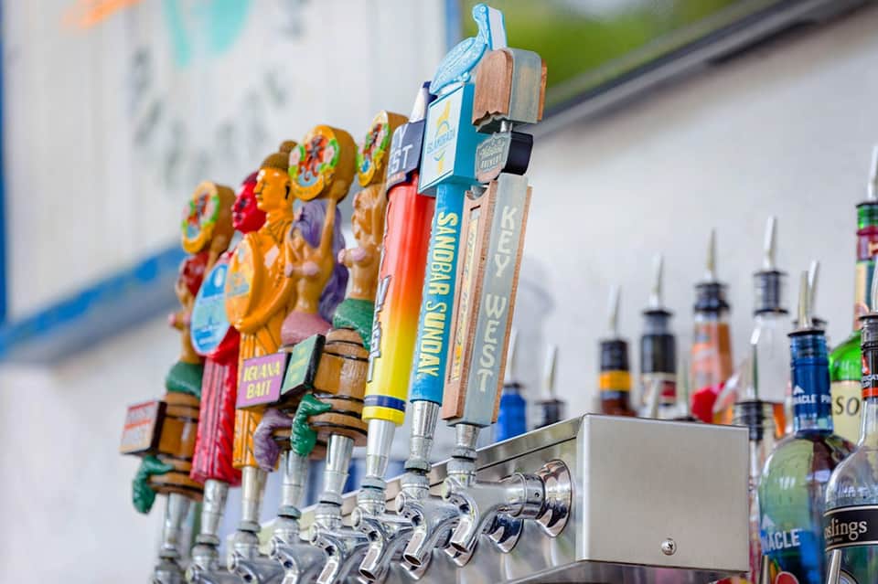 Colorful beer taps with decorative wooden handles at a resort bar
