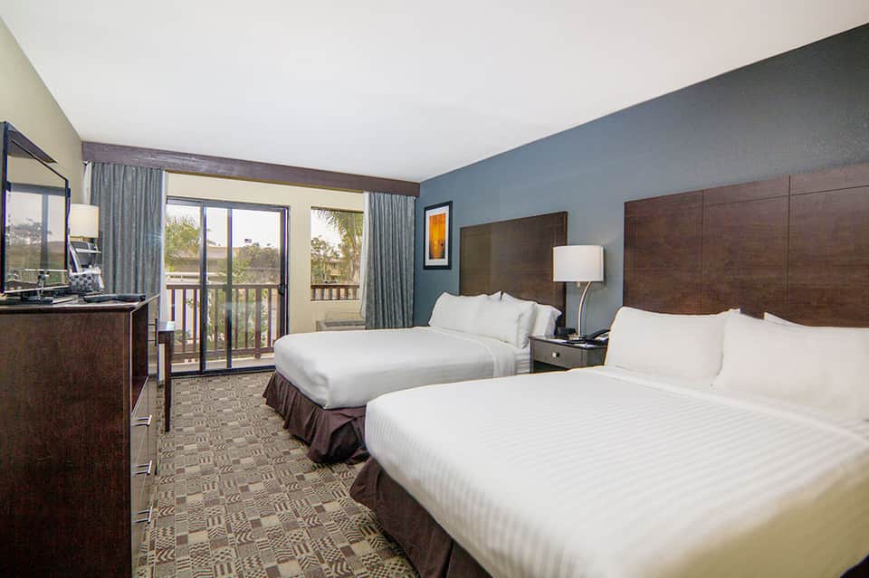 Hotel double bed room with balcony, desk, modern furnishings, and ocean view