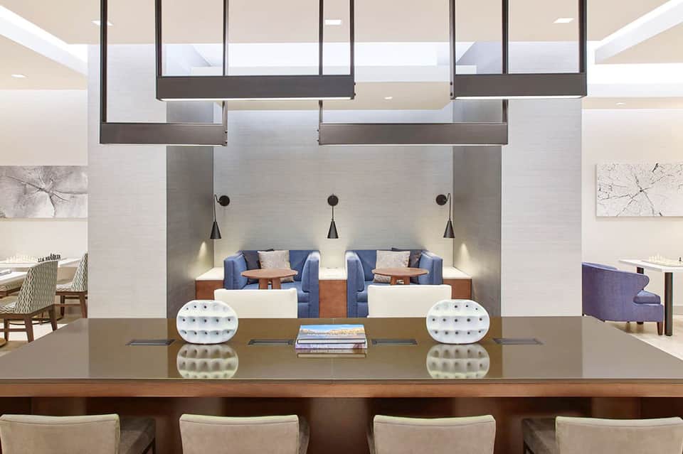 Modern hotel lobby with reception desk, pendant lighting, and contemporary seating areas