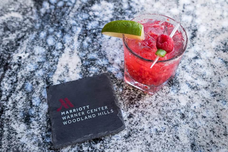 Raspberry mojito cocktail with lime wheel on Marriott Warner Center Woodland Hills branded napkin