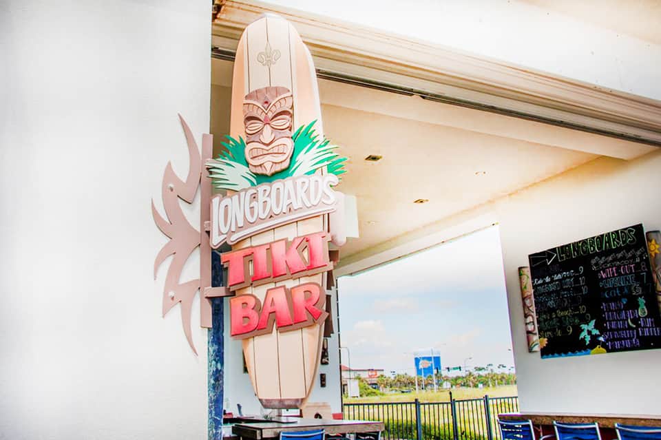 Longboards Tiki Bar sign featuring surfboard design and tropical tiki mask decoration