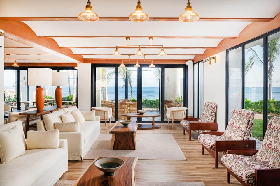 Modern lounge with ocean views, wooden beams, and coastal interior design