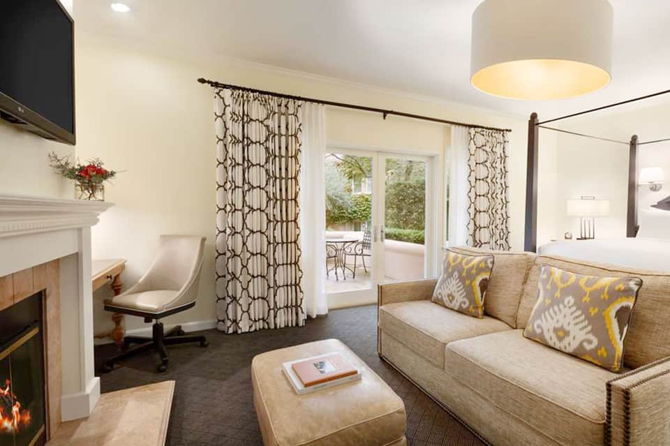 Luxury suite with fireplace, canopy bed, patio doors, and elegant furnishings