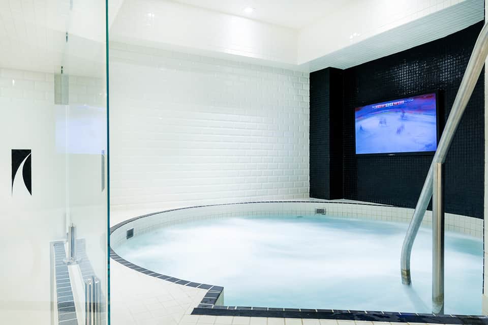 Modern circular hot tub spa with white and black tile interior