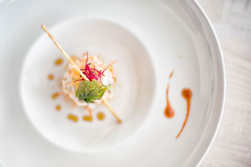 Elegantly plated fine dining dish with edible flowers and artistic presentation