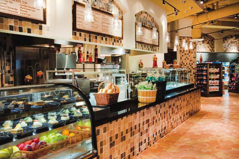 Bakery cafe counter with pastries, desserts, and menu boards displayed
