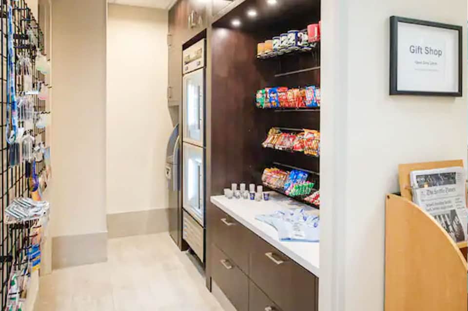 Resort gift shop interior with shelves of snacks, drinks, souvenirs, and merchandise displays