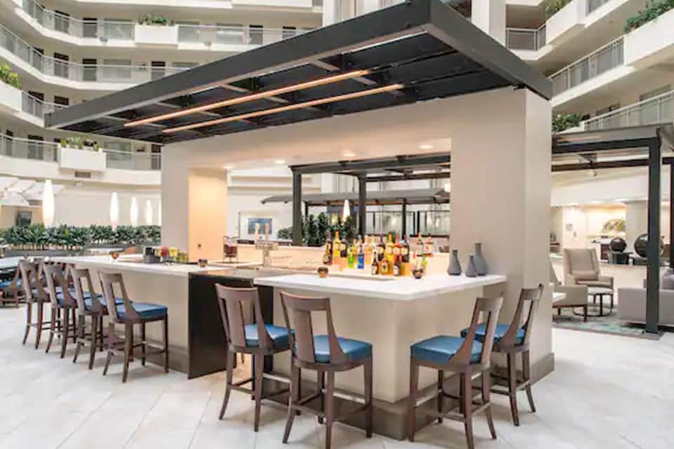 Contemporary bar counter with seating and amber beverage bottles under black canopy