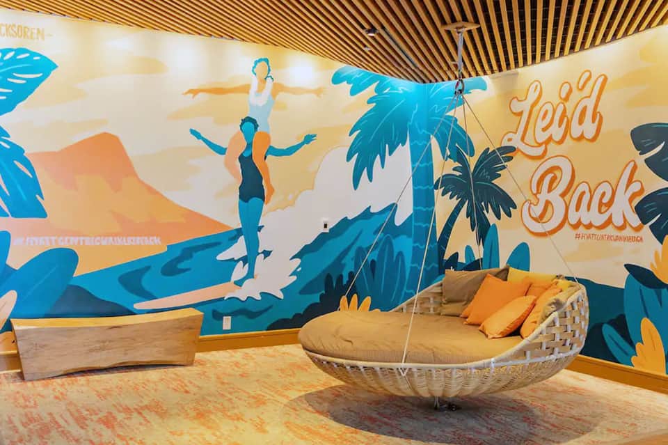 Colorful wall mural with beach scene and hanging woven swing chair