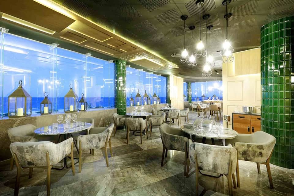 Upscale restaurant interior with panoramic ocean views and contemporary furnishings