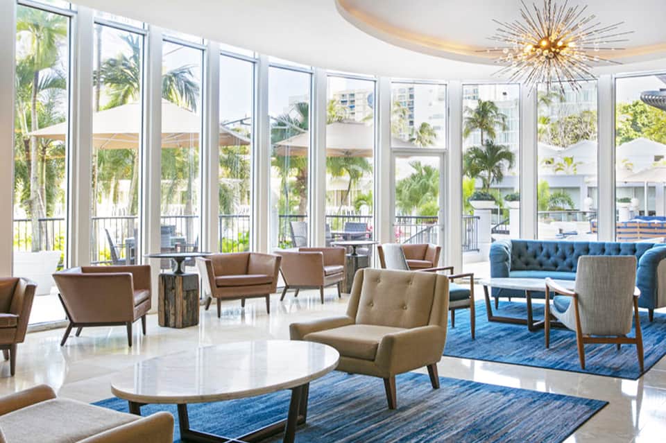 Contemporary lobby lounge with floor-to-ceiling windows overlooking resort grounds