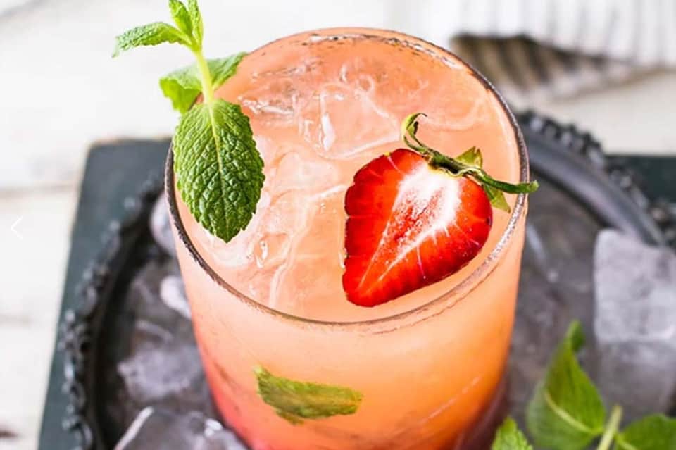 Refreshing strawberry and mint cocktail with ice served in crystal glass