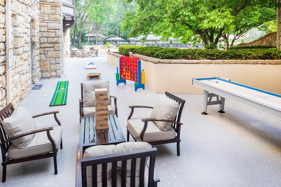Outdoor recreation area with cornhole, giant Connect Four game, air hockey table, and lawn games