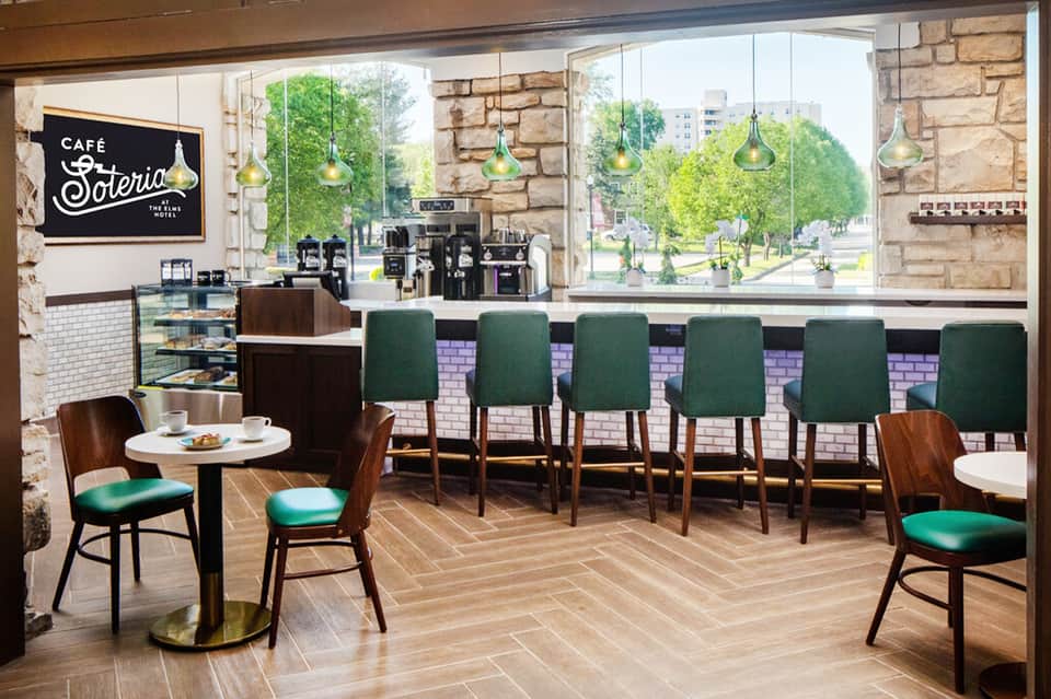 Modern café interior with green bar seating and large windows