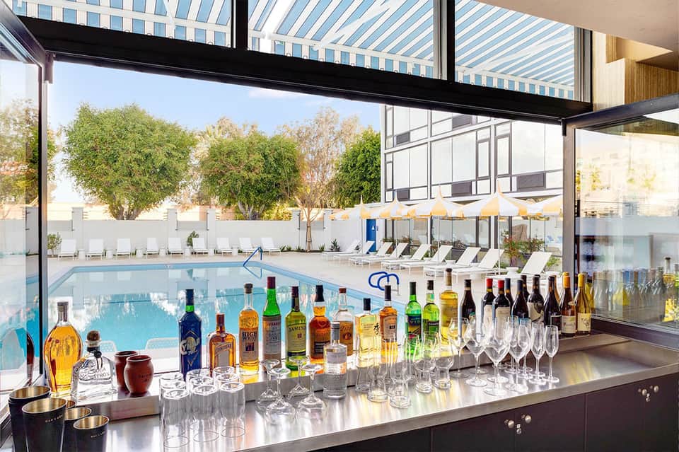 Modern bar with full liquor selection overlooking indoor pool and resort grounds