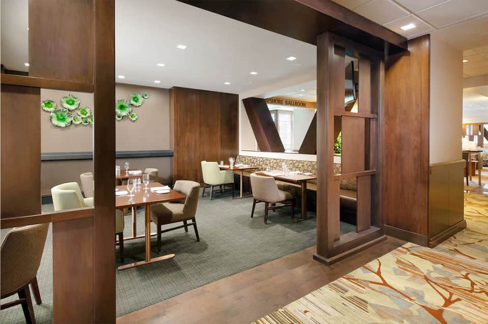 Fine dining restaurant interior with wood partitions, tables, and elegant modern décor