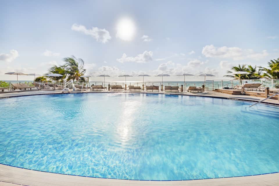 Oceanfront resort pool with lounge chairs and beach view