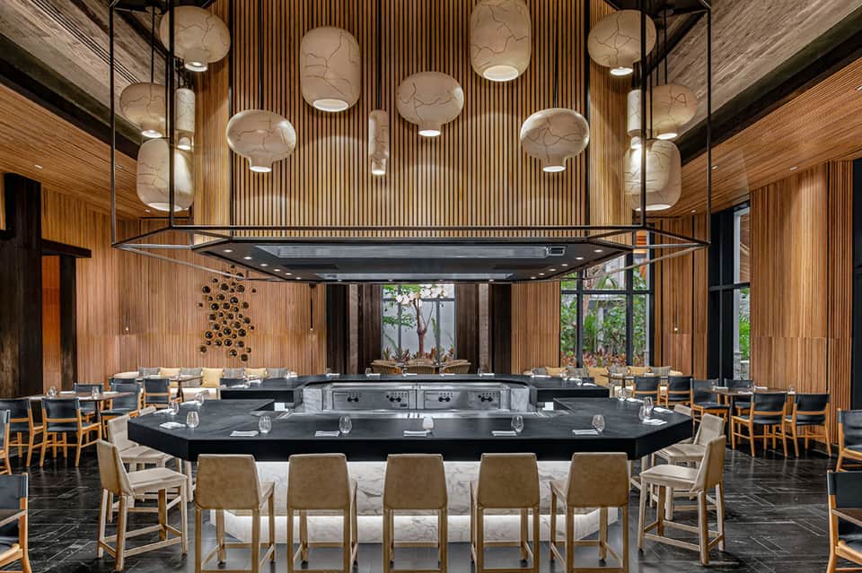Contemporary dining space with wood paneling and hanging pendant lights.