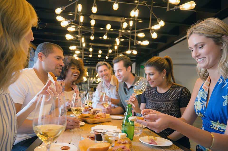 Group of friends dining together at an elegant restaurant under warm pendant lighting