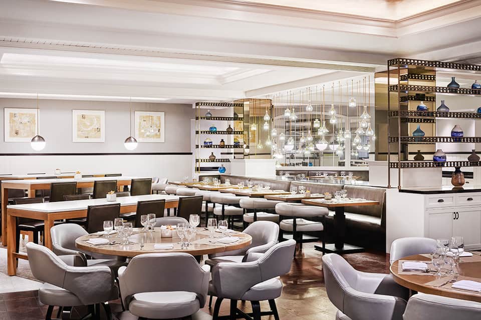 Fine dining restaurant interior with circular tables, pendant lighting, and modern design