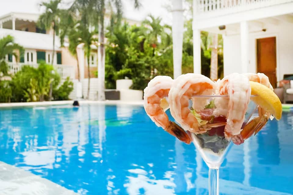 Shrimp cocktail by the pool overlooking tropical gardens and ocean at a resort