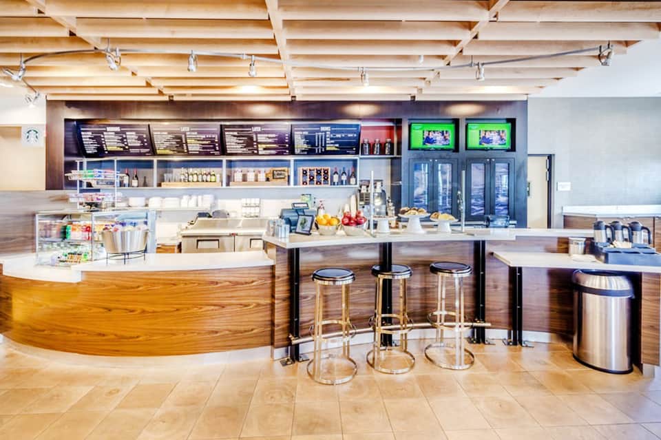 Modern resort café with curved counter, stools, and wooden accents