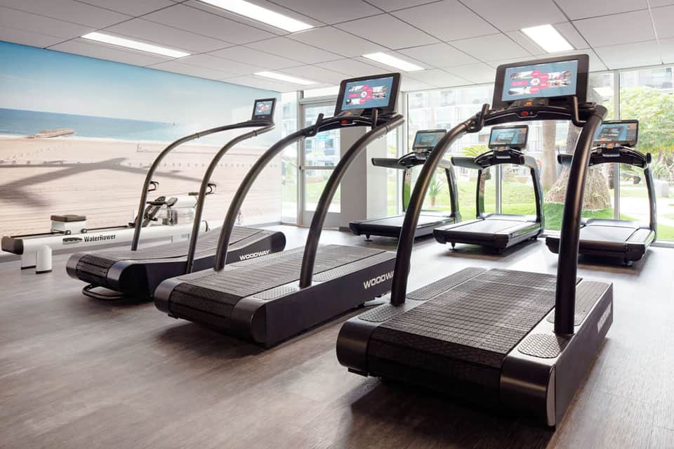 Fitness center with treadmills featuring screens overlooking a beach landscape view