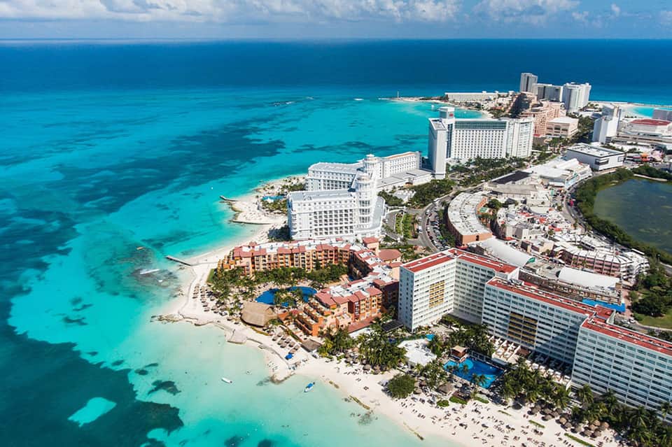 Aerial view of beachfront resort with turquoise waters and sandy beach