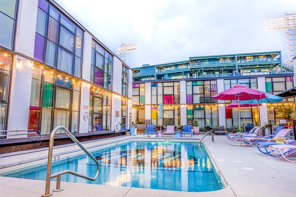 Contemporary hotel pool with colorful building facade and umbrellas