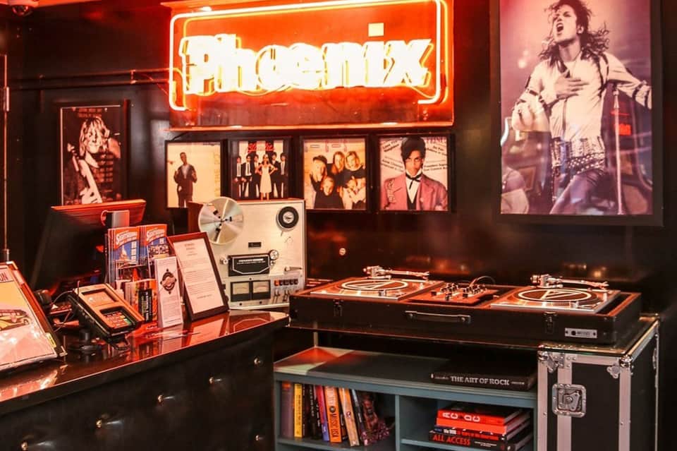 Phoenix band neon sign display with vinyl records and memorabilia in a music museum exhibit
