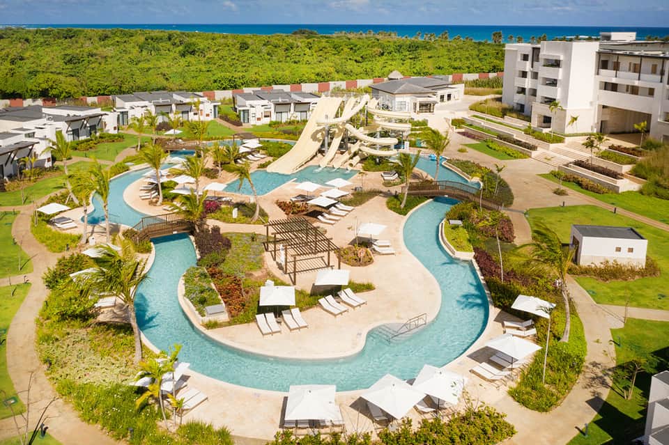 Aerial view of sprawling resort complex with lazy river, pools, and tropical landscaping