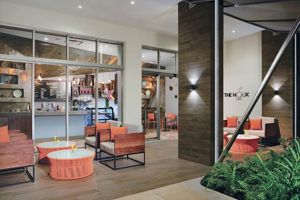 Modern cafe interior with coral accents, wood features, and contemporary furnishings