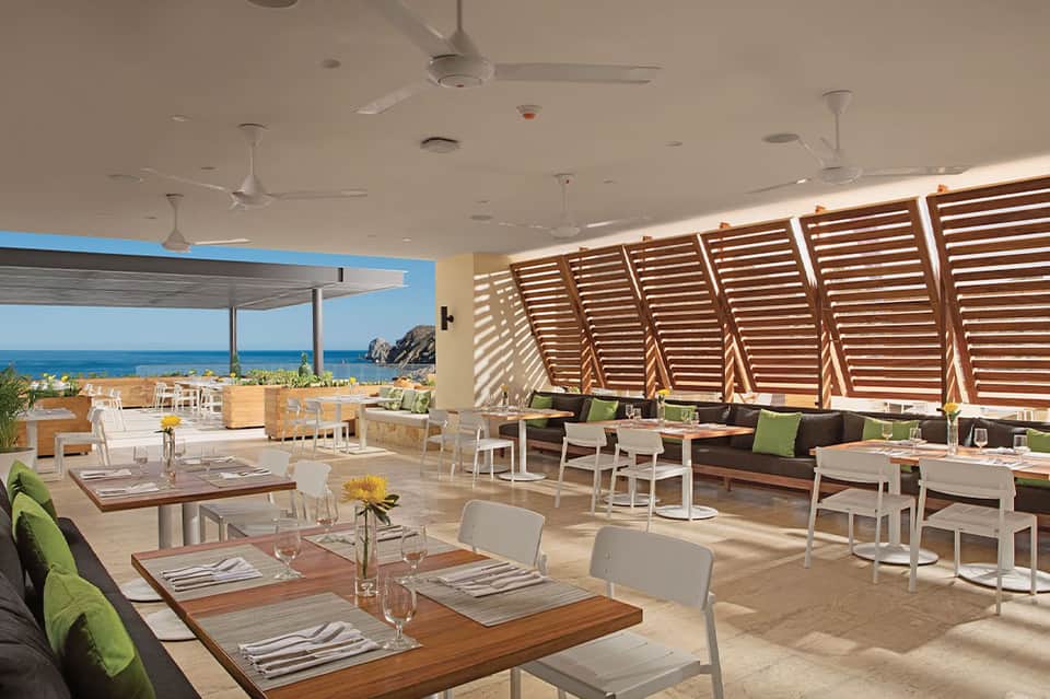 Beachfront restaurant with wooden louvered screens, ocean views, and contemporary coastal design